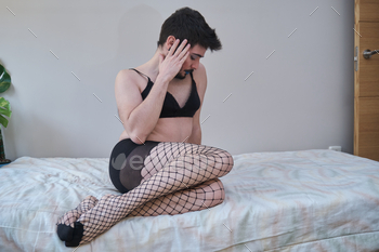 Young man wearing fishnet stockings and bra.