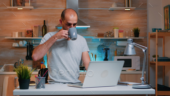 Freelancer working from home drinking coffee stock photo NULLED