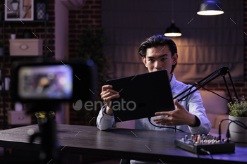 Male freelancer filming product review video stock photo NULLED