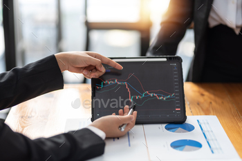 Investor team analyzes the stock market on a tablet at the meeting. stock photo NULLED