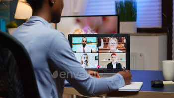 African freelancer working remotely discussing with partners stock photo NULLED