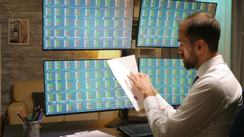 Back view of stock market trader in home office stock photo NULLED