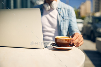 Busy freelancer going to drink coffee in cafe stock photo NULLED