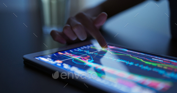 Finger touch on tablet computer with stock market data