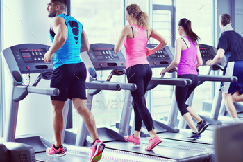 Group of people running on treadmills stock photo NULLED