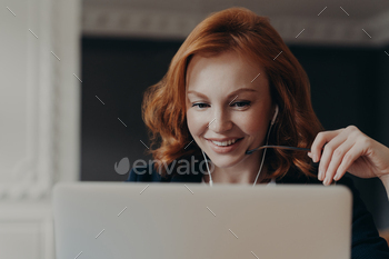 Happy young woman freelancer concentrated at laptop stock photo NULLED