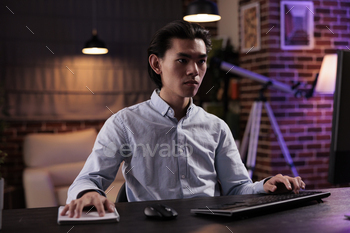 Male freelancer doing remote work on computer stock photo NULLED