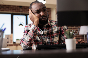 Stressed overworked man doing freelance work stock photo NULLED