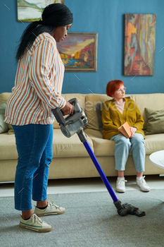 Woman helping to elderly woman in housework stock photo NULLED