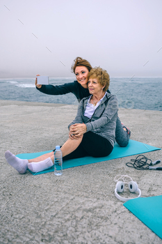 Woman taking selfie with senior woman stock photo NULLED