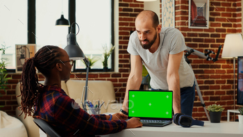 Young freelancer using laptop to work with greenscreen stock photo NULLED