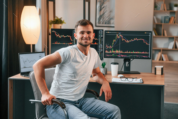 Young stock broker is working in the office by using computer