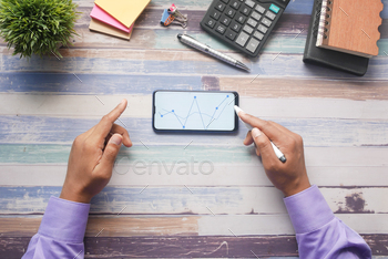 young man analyzing stock chart on smart phone stock photo NULLED